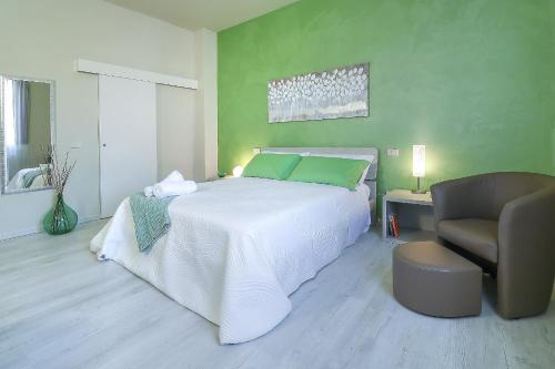 a bedroom with a large white bed and a chair at B&B Ulivo Gaio in San Miniato