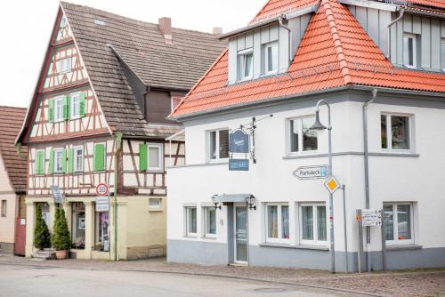 a white building with an orange roof on a street at Sali Homes - GaesteHaus Lamm Obersulm in Obersulm