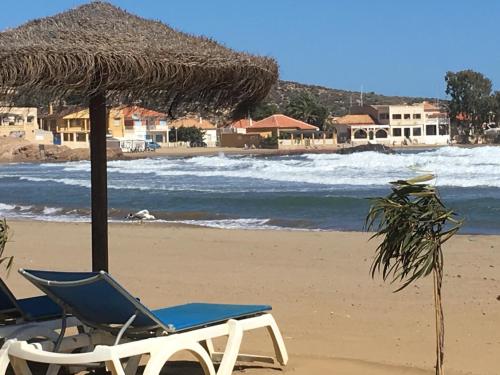 two chairs and an umbrella on a beach at Condado de Alhama in Alhama de Murcia