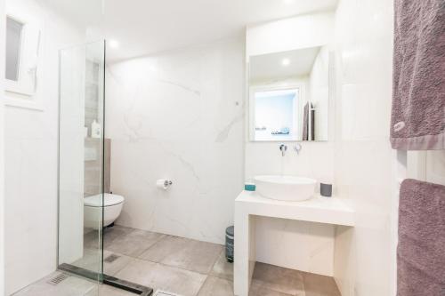 biała łazienka z umywalką i toaletą w obiekcie Modern White Tower Apartment w Salonikach