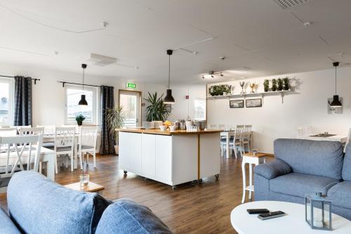 a living room with blue couches and a dining room at Brink Hotell in Eslöv