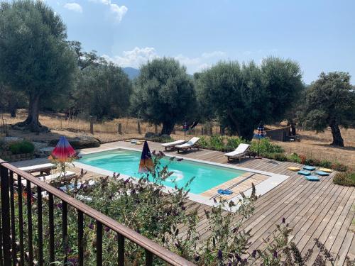 a swimming pool in a yard with a wooden deck at Domaine de Tappa - Casa Filicina in Sollacaro
