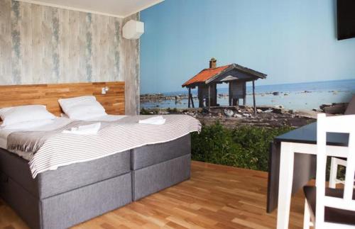 a bedroom with a bed and a view of a beach at Drottning Ödas Boende in Degerhamn