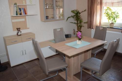 una cucina con tavolo e sedie in legno, tavolo e sedie di Moderne und sehr gemütliche Ferienwohnung a Wattenbach