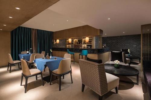 a restaurant with tables and chairs and a bar at Ramada by Wyndham Zhenjiang City Center in Zhenjiang