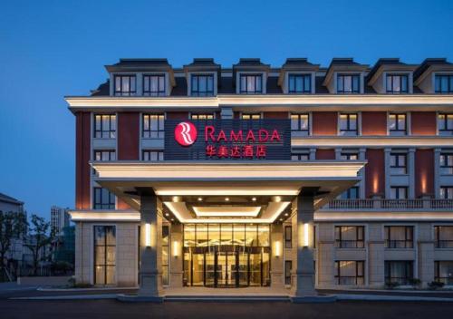 a hotel with a sign on the front of it at Ramada by Wyndham Zhenjiang City Center in Zhenjiang