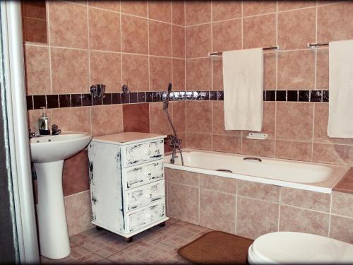 łazienka z umywalką, wanną i toaletą w obiekcie Aqua Terra Guest House w mieście Lydenburg