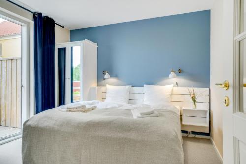 a bedroom with a large bed with blue walls at Skagen Harbour Hotel in Skagen