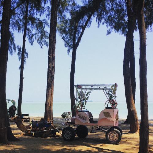 a carriage on the beach with trees at Porte Bleue Pantai Puteri in Melaka