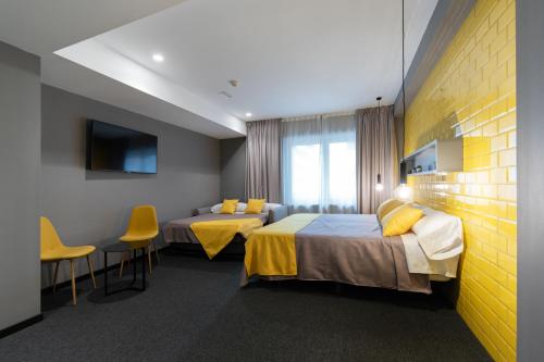ein Hotelzimmer mit zwei Betten und einem Fernseher in der Unterkunft Nest Style Valencia in Valencia
