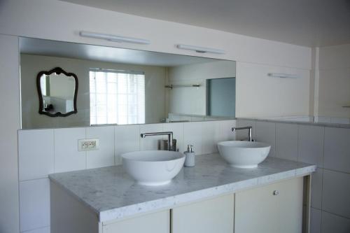 een badkamer met 2 wastafels en een grote spiegel bij B&B Tempelhof in Gent
