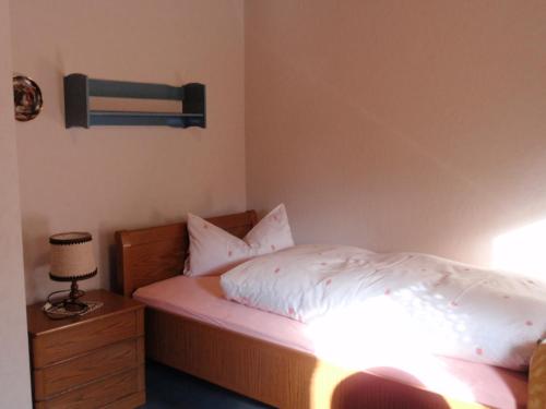 a bedroom with a bed with white sheets and a lamp at Ferienwohnung Carmen in 36396 Steinau-Ulmbach in Steinau an der Straße