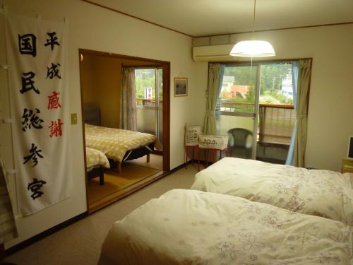 a hotel room with two beds and a mirror at Futami Terrace B in Ise