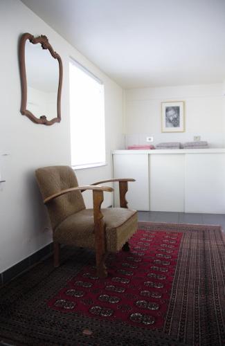 a room with a table and a chair and a mirror at B&B Tempelhof in Ghent