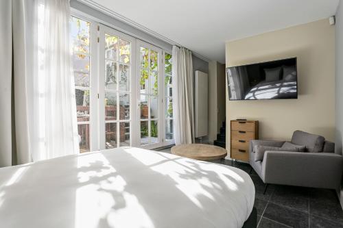 a bedroom with a bed and a chair and a television at Fish Market B&B in Brussels
