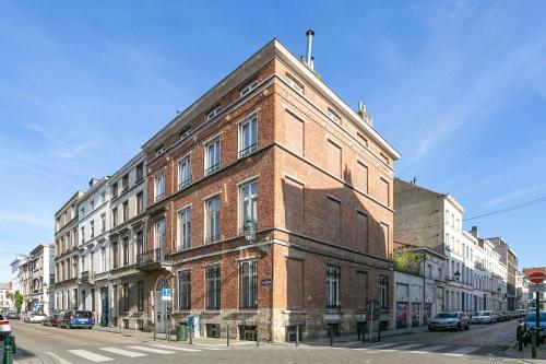 a red brick building on a city street with cars at Fish Market B&B in Brussels