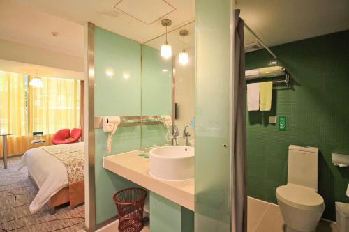 a green bathroom with a sink and a toilet at Shanshui Trends Hotel - Huaqiangbei in Shenzhen