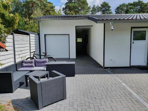 a house with a patio with purple furniture and a garage at Monteurzimmer Senzig in Königs Wusterhausen