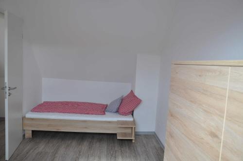 a room with a bench with two red pillows on it at Ferienwohnung Vollert in Obersulm