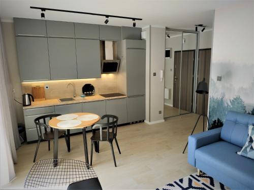巴爾托希采的住宿－Apartament Limanowskiego 20/6，客厅配有桌子和蓝色沙发
