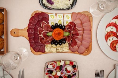 a table with a plate of food with meat and vegetables at Hotel Livade in Čačak