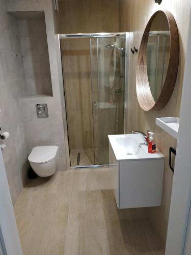y baño con ducha, aseo y lavamanos. en Apartament Limanowskiego 20/6, en Bartoszyce