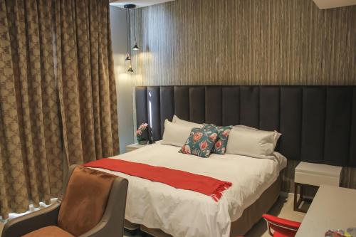una camera con letto, tavolo e sedia di Green Avenue Apartments a Gaborone