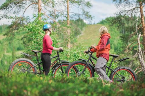 two women are riding bikes in a field at Hotel Paljakka in Kotila