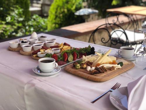 a table with two plates of food and cups of coffee at Çalıkuşu Tarihi Beşevler in Tekirdag