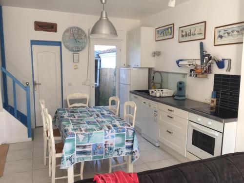 - une cuisine avec une table, des chaises et un comptoir dans l'établissement La Bethencouroise, à Béthencourt-sur-Mer