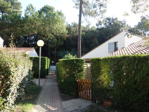 a driveway leading to a house with a fence at Holiday Home Bois d'Eleis-2 by Interhome in La Palmyre