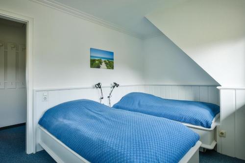 2 camas en una habitación con sábanas azules en App. Strandnah, en Rantum