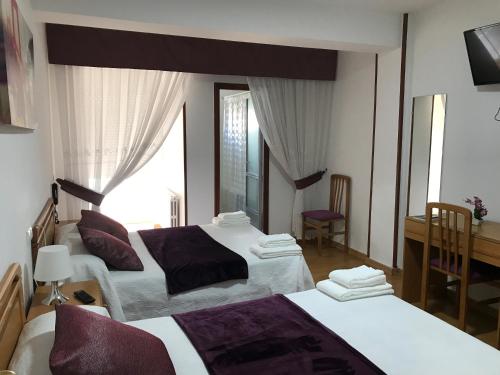 カルバージョにあるPensión Ramaのベッド2台と鏡が備わるホテルルームです。