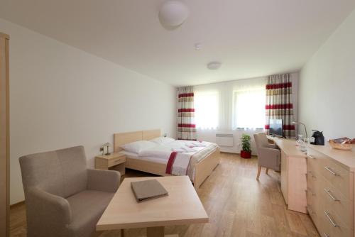 1 dormitorio con cama, escritorio y mesa en Resort Johanka, en Kamenice nad Lipou