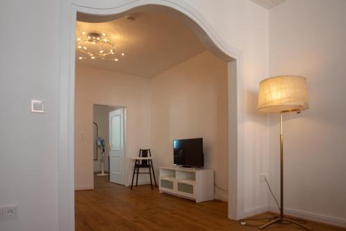 a living room with a lamp and a television at Hotel-Restaurant Hackteufel in Heidelberg