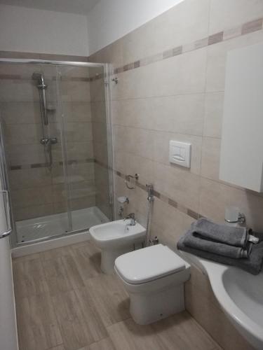 a bathroom with a shower and a toilet and a sink at Casa vacanze Villa Algieri in Schiavonea