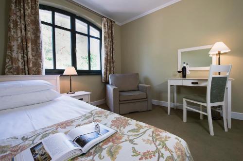 a hotel room with a bed and a desk with a book at Warmia Park in Olsztyn