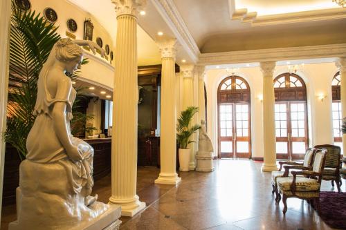 a statue of a woman in a lobby with columns at Riverside Hotel Saigon in Ho Chi Minh City
