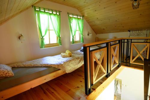 a bedroom with a bunk bed and two windows at Planinska Gospa in Bajina Bašta