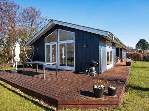 una casa con una terraza con una mesa de picnic. en 6 person holiday home in Odder en Norsminde