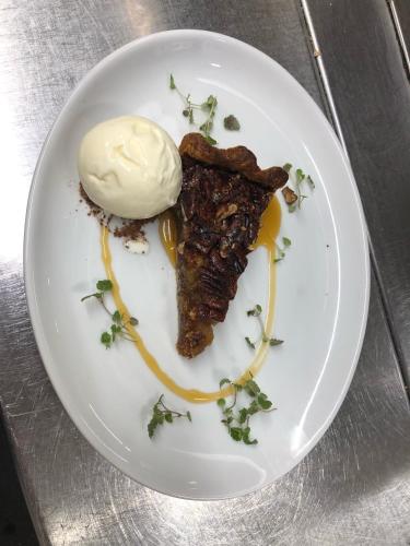 a plate of food with a piece of meat and ice cream at Collingwood Arms Hotel in Cornhill-on-tweed