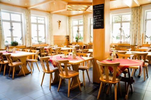 un restaurante con mesas, sillas y ventanas en Wallfahrts-Gaststätte Heilbrünnl, en Roding