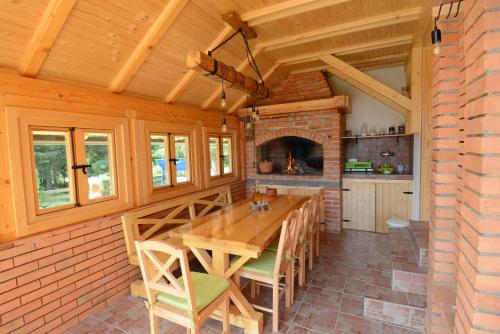 a dining room with a wooden table and a fireplace at Planinska Gospa in Bajina Bašta