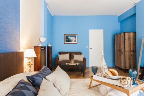 a living room with blue walls and a bed with a toy boat on a table at Cozy, Central, Safe Double rooms in apartment, close to Acropolis in Athens