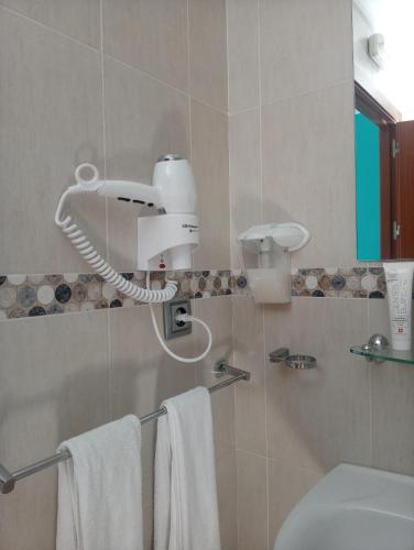 a bathroom with a blow dryer on the wall at Hostal Victoria Mar in Chipiona