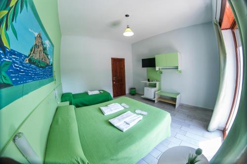 a room with a green bed and a room with a table at B&B Le isole in Naples