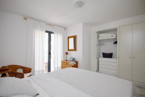 a white bedroom with a white bed and a window at Bear Holiday - Apartment Lynn with Seaview in Moraira near the Beach in Moraira