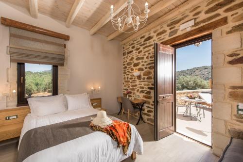 a bedroom with a large bed and a balcony at Lameriana Secret Village in Lamerianá