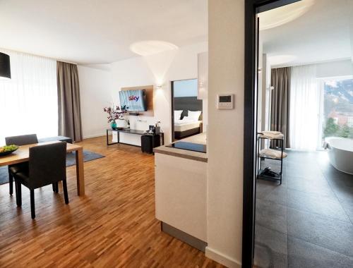 a hotel room with a bed and a table and a tub at Apparthotel Rivers Passau in Passau