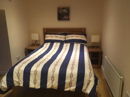 a bedroom with a bed with blue and white stripes at Nanny Quinn's Apartment in Killucan